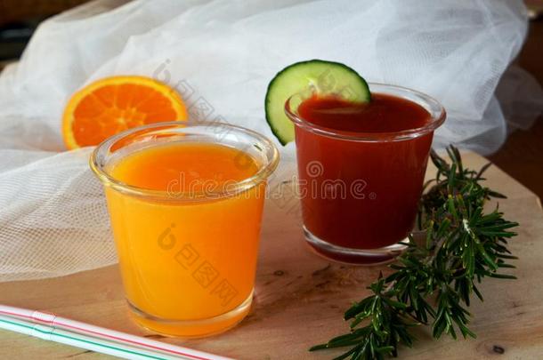 新鲜的橘子和西红柿冰沙在玻璃杯上。