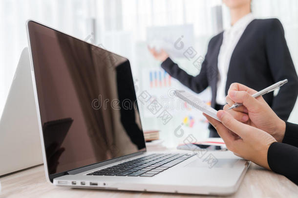 商务人士在会议上使用笔记本电脑和财务图表