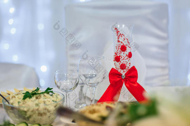 玻璃装饰着红色丝带作为节日的婚礼桌