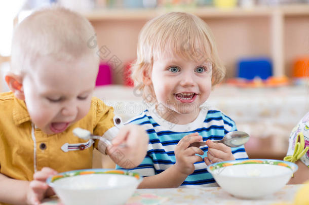 有趣的微笑小孩子在幼儿园吃饭
