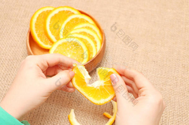 水果在一个木碗里，他的<strong>手撕</strong>成橙色，准备食用