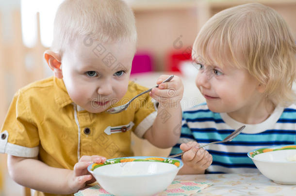 有趣的微笑小孩子在幼儿园吃饭