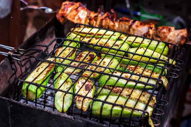 新鲜健康的绿色西葫芦小黄瓜，在木炭烧烤架上准备。