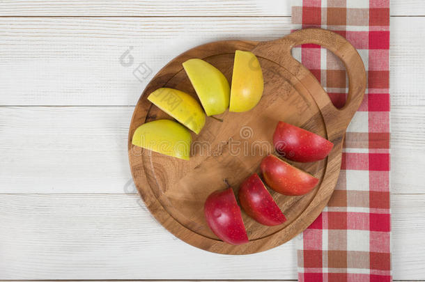 苹果躺在<strong>木板</strong>上，格子厨房<strong>桌布</strong>在顶部。