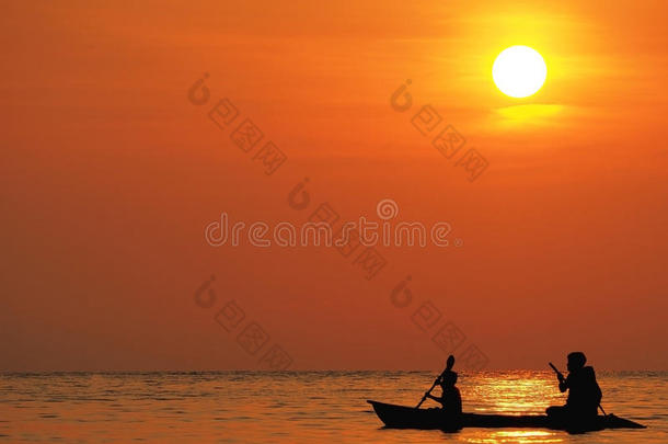 模糊散焦美丽的橙色天空日落在海面上与人和男孩划艇在海上的轮廓，在高科德，泰国。