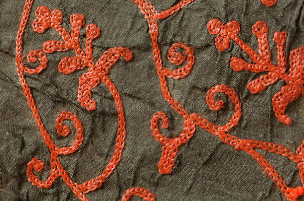 红色花卉图案刺绣线的细节在一个旧的黑色披肩。