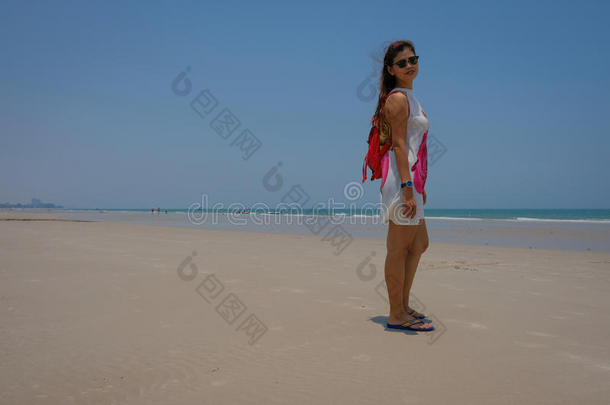模特在海滩上俯瞰蓝天的全长图像。