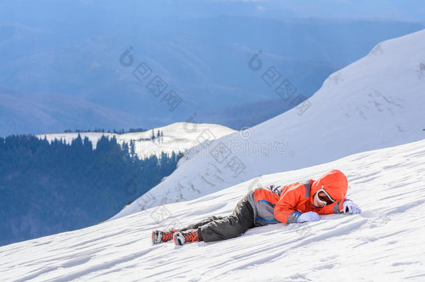 男孩在新鲜的雪上摔倒了。 快乐的男孩躺在雪地上。 可爱的李