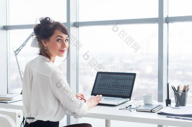 有吸引力的女商人使用PC在办公室工作，在笔记本电脑屏幕上在线搜索和研究商业想法。
