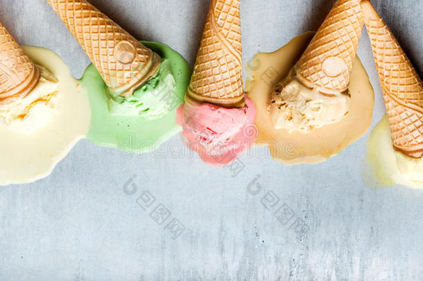 不同口味的彩色冰淇淋锥。 融化的铲子。 顶部视图，钢金属背景