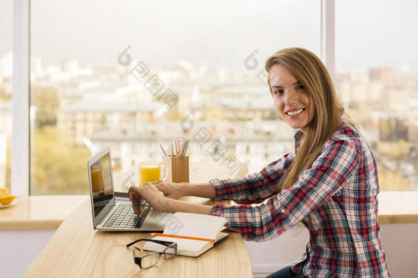 在笔记本电脑上工作的微笑女孩