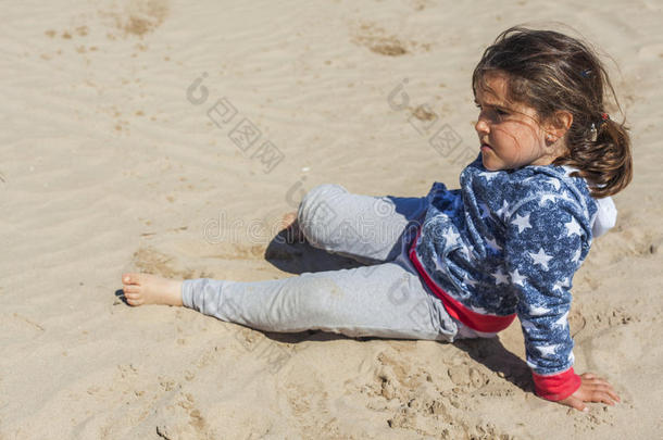 在复活节的一个<strong>刮风</strong>的日子里，女孩在沙滩上摆姿势。 s