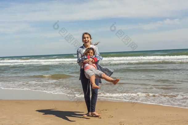 全速少年和她的妹妹在海滩的海边玩耍。