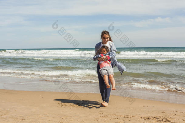 全速少年和她的妹妹在海滩的海边玩耍。