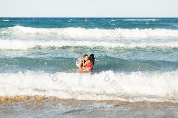美丽的年轻夫妇在海滩上享受和享受乐趣
