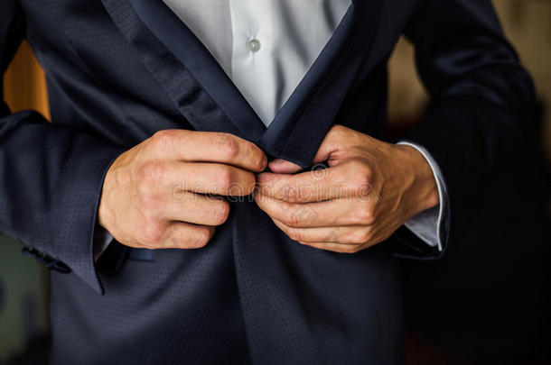 夹克上的正确按钮，双手特写，穿衣，男人的风格，