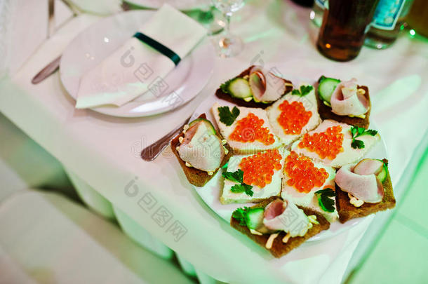 优雅的婚礼接待桌上有食物，红色鱼子酱在黄油上