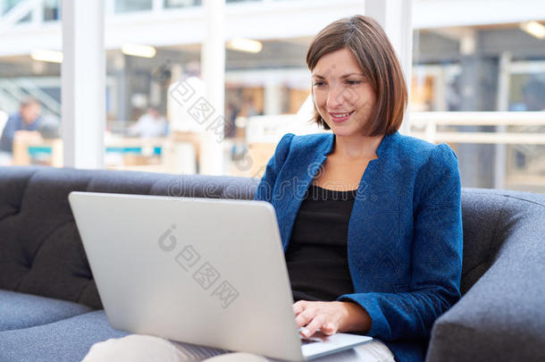 有吸引力的年轻女<strong>公务员</strong>，办公室沙发上有笔记本电脑