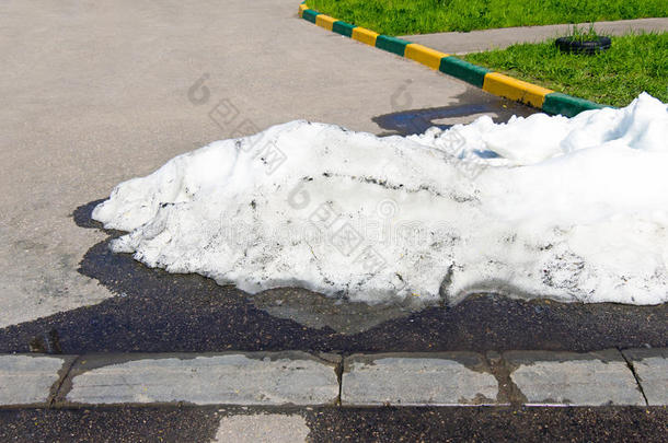 沥青路上躺着一堆又脏又白的雪