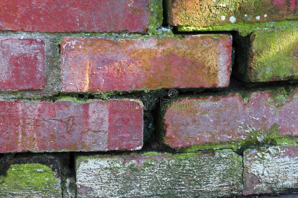 关闭弯曲的老式破碎的红色砖墙