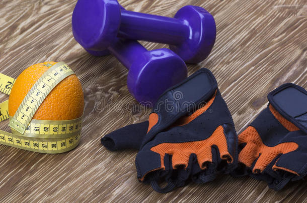 哑铃、橙色、健身手套和卷尺的特写镜头