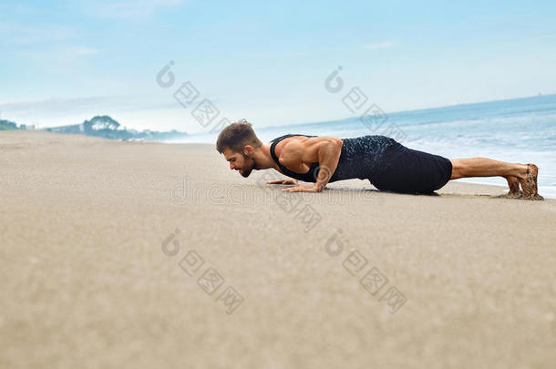 健身者锻炼，在海滩上做俯卧撑运动。 体育运动