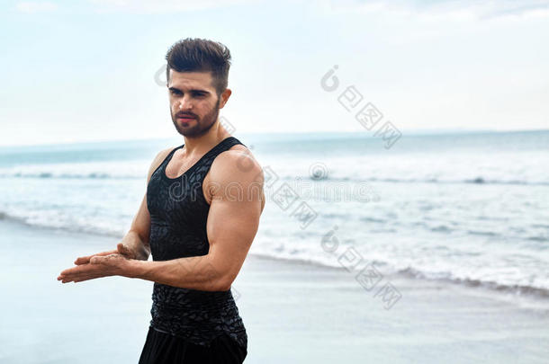 在海滩上穿着运动服的帅哥。