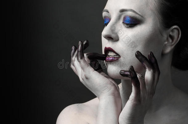 美丽的女人，明亮的烟雾眼睛化妆，黑<strong>白皮肤</strong>和手指在油漆