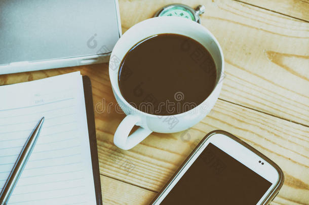 <strong>商务办公</strong>场所，配有咖啡杯、智能手机、笔、笔记本，