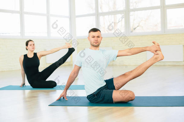 迷人的瑜伽夫妇，男人和女人，在训练大厅练习练习