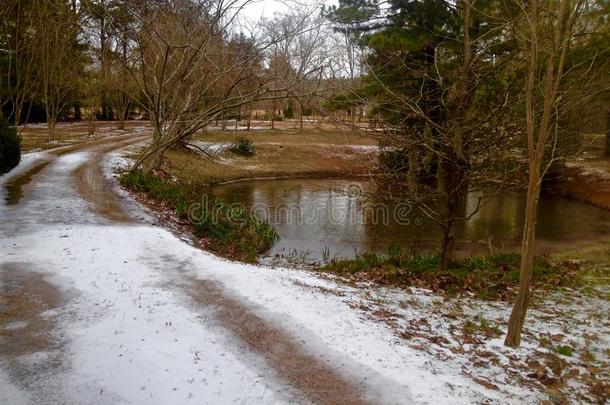 <strong>砾石路</strong>被雪覆盖在池塘旁边