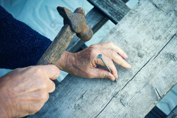 成熟男人的特写用旧锤子指甲