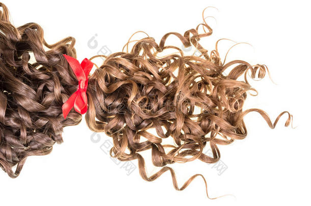棕色波浪状的头发系在白色上的红色丝带上。