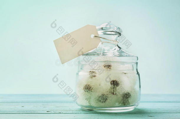 彩球或蒲公英在许愿罐与纸标签，复古绿松石背景，作出一个愿望的概念，不寻常的礼物或礼物