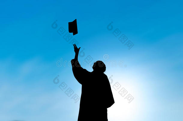 毕业生在毕业日扔帽子，剪影