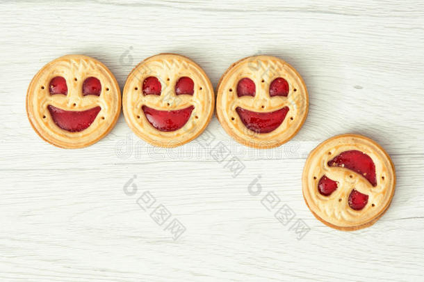 四个圆形饼干笑脸，其中一个掉下来