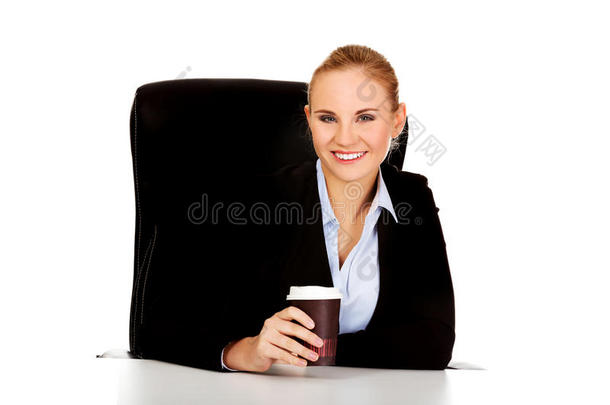 <strong>商务</strong>妇女在桌子后面的<strong>纸杯</strong>里喝咖啡