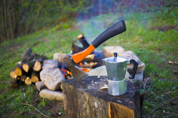 火旁的咖啡机和斧头。
