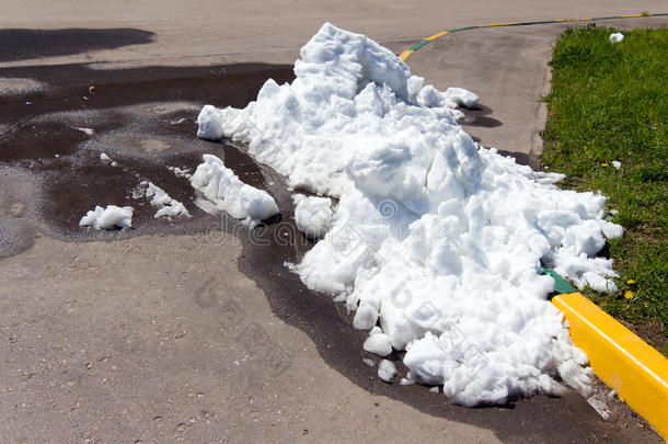 沥青路上躺着一堆又脏又白的雪