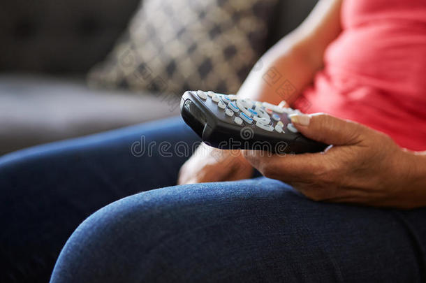 <strong>特写</strong>老年妇女坐在沙发上拿着电视<strong>遥控器</strong>
