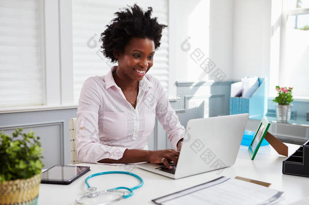 在办公室工作的黑人女医生使用笔记本电脑