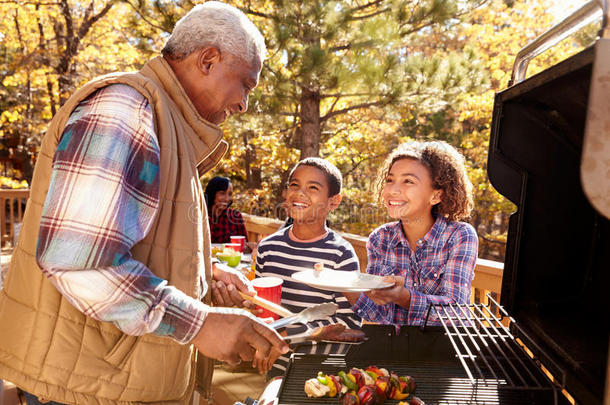 祖父母和孩子们一起享受户外烧烤