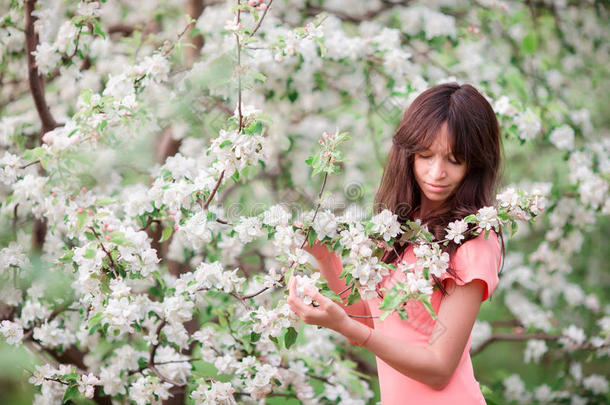 美丽的女孩在春天的樱桃花园里享受气味