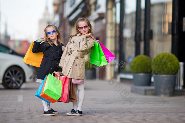 可爱的小女孩带着袋子在户外购物