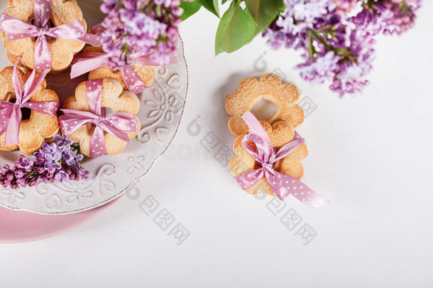 饼干与粉红色丝带在白色盘子与丁香花，顶部