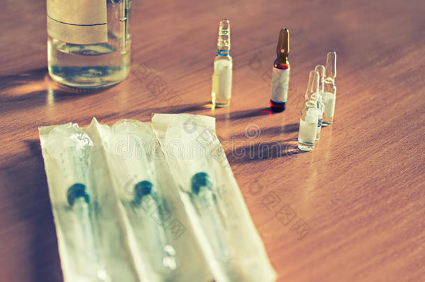药物在医疗瓶和注射器上的桌子色调图像，Instagram效应