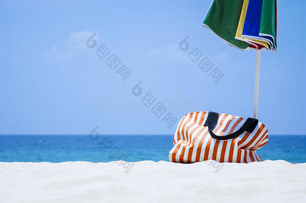 沙滩上的包和伞夏季户外度假旅行