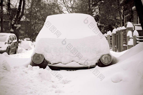 汽车被困在雪中的街道上，只有前灯显示