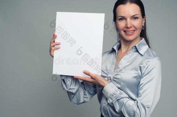 开朗的黑发女人拿着一张白色的空白海报