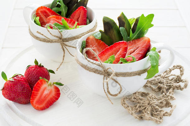 新鲜沙拉配草莓，阿鲁古拉，鳄梨和<strong>黑芝麻</strong>在白色杯子里